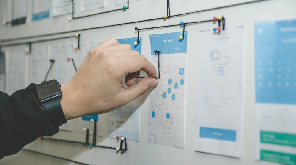 Diseñador organizando pantallas y wireframes de una landing page